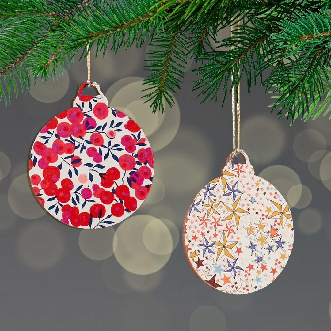 two christmas ornaments hanging from a christmas tree